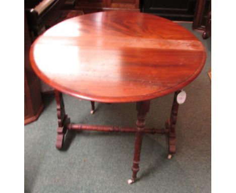 A Victorian oval mahogany gate leg tea table with spiral turned legs and stretcher, pierced foliate scrolled raisers, on whit