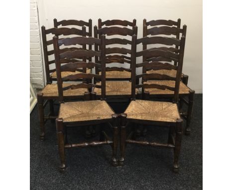 A set of eight rush seated ladder back dining chairs