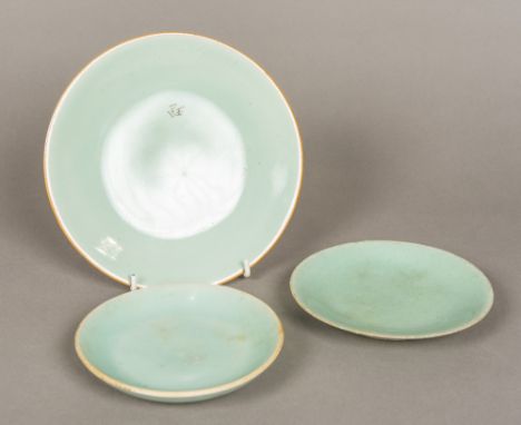 Three Chinese porcelain plates, all with celadon glaze, all with blue painted archaistic seal mark to base.  The largest 20 c