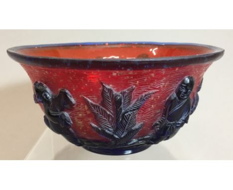 A Chinese 19th/20th century Peking glass bowl, carved with four boys in blue on a red ground worked with snowflakes, four cha