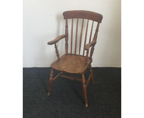 A Victorian stick back solid seated open armchair 