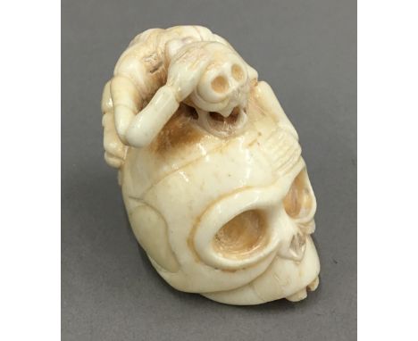 A bone netsuke formed as a skull