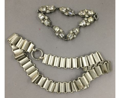 An Art Deco paste set white metal bracelet, together with a white metal articulated necklace