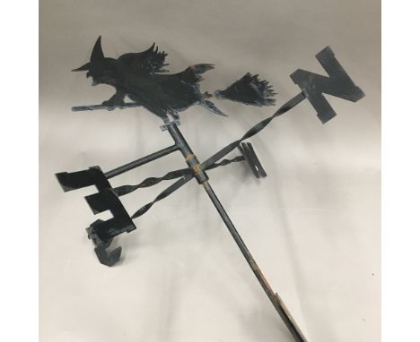 A weather vane topped with a witch on a broomstick