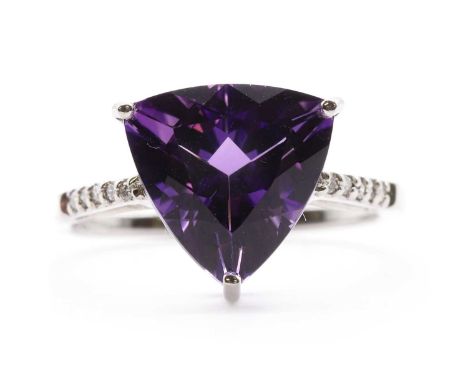 A 9ct white gold amethyst and diamond ring,a triangular mixed cut amethyst, approximately 10.50mm, claw set to shoulders micr