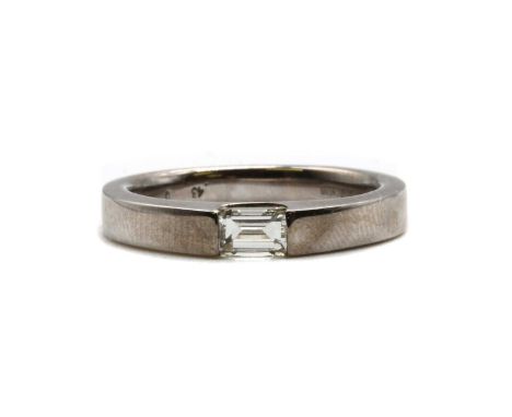 An 18ct white gold single stone diamond ring, a modified step cut diamond, end set in a landscape position, to tapered should