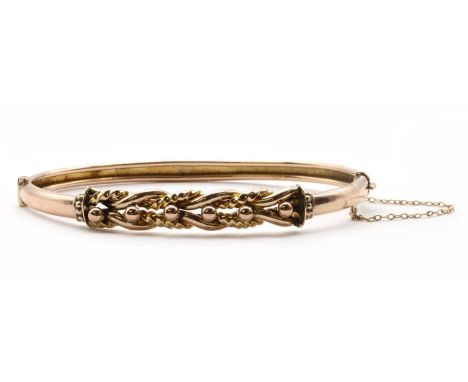 A gold hollow oval hinged bangle, with twisted wire and bead decoration to the top half, and a plain lower half, with conceal