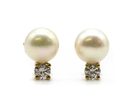 A pair of gold cultured pearl and diamond earrings, a cultured pearl, 7.60-7.80mm, cut set, surmounted by a brilliant cut dia