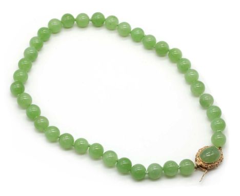 A single row uniform nephrite jade bead necklace,a row of uniform nephrite jade beads, approximately 10mm, stung knotted to a