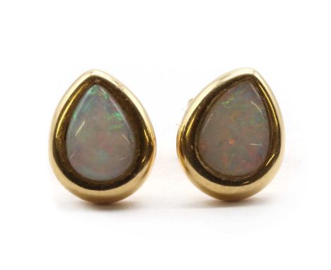 A pair of gold opal stud earrings, a pear cabochon opal, bezel set, to post and butterfly fittings, marked 18k750, tested as 