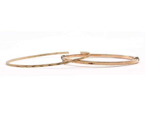 Two gold bangles, comprising a hollow hinged bangle with figure of eight safety catch, tested as approximately 9ct gold, and 