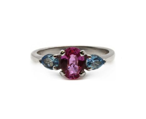 An 18ct white gold pink sapphire and aquamarine three stone ring, and oval mixed cut pink sapphire, approximately 8 x 6mm, wi