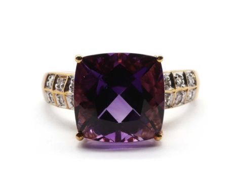 A 9ct gold amethyst and diamond ring,a cushion cut amethyst, approximately 11mm, claw set, to slightly tapered shoulders grai