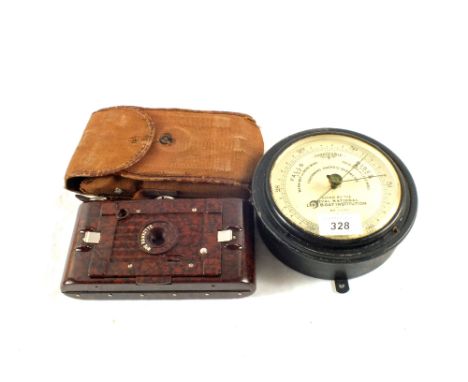 A Dollond RNLI fisherman's aneroid barometer and a Bakelite Hawkeye folding camera