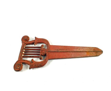 A Victorian iron foot scraper cast in the form of a harp