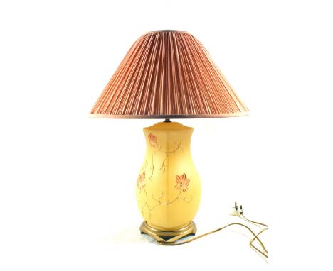 A table lamp with a luminous glass floral body with a pink shade