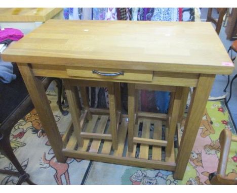 A solid oak kitchen table with slatted lower shelf and single drawer, together with two matching stools 