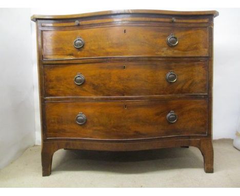 A George III mahogany serpentine fronted dressing chest, the top having a satinwood and string inlaid border, over a brushing