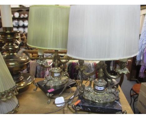 A mid 20th century brass standard lamp with ornate decoration and a gold coloured shade with tassels, together with a brass c