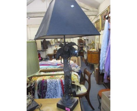 A composition black table lamp in the form of a monkey climbing a coconut tree, having a black lamp shade 