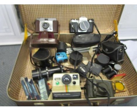 A suitcase containing various cameras, lens and accessories to include a Polaroid land camera 1000, an Ilford Sportsman, a Pe