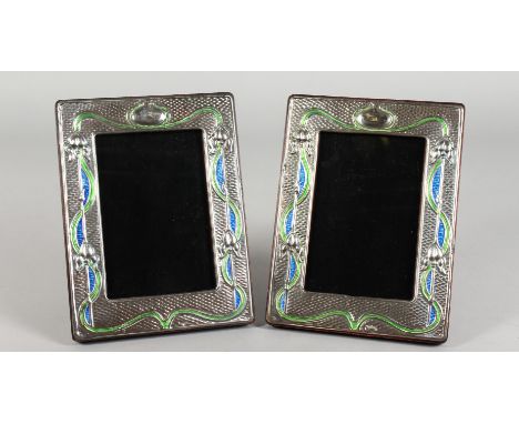 A PAIR OF ART NOUVEAU STYLE SILVER AND ENAMEL PHOTO FRAMES. 7.5ins high x 5.75ins.
