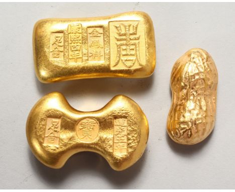 THREE NOVELTY CHINESE GOLDEN-COLOURED SCROLL WEIGHTS. 2ins and 2.5ins long.