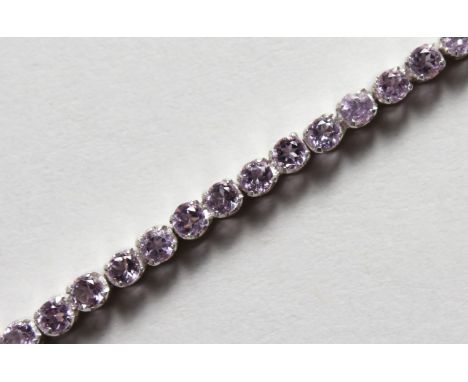 A SILVER AND AMETHYST LINE BRACELET. 7ins long.