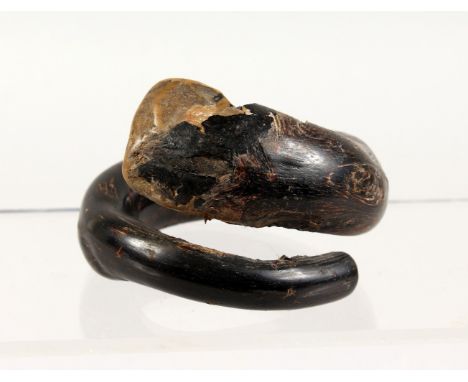 AN UNUSUAL TRIBAL BANGLE, possibly made of black coral. 4ins wide.