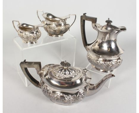 A FOUR PIECE EDWARDIAN SILVER TEA SET, with repousse decoration, comprising teapot, hot water jug, milk jug and sugar basin. 