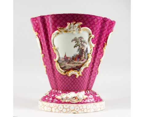 AN AUGUSTUS REX PORCELAIN VASE AND STAND, in the Meissen style, pink scale ground, the vase and stand painted with vignettes 