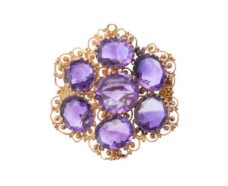 An early Victorian gold and amethyst brooch, circa 1840, claw set with seven scissor cut amethysts in a gold filigree flower 