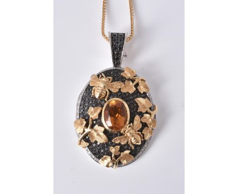 An 18 carat gold citrine, diamond and black diamond locket pendant by Theo Fennell, the oval locket set with a central oval c