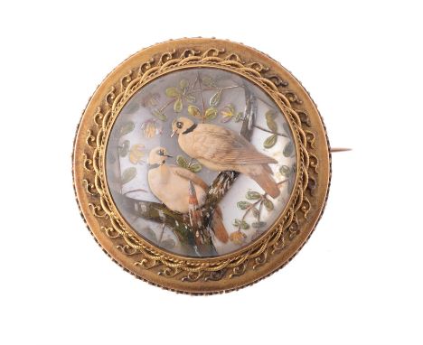 A mid Victorian reverse painted intaglio brooch, circa 1880, the reverse intaglio painted with a pair of collared doves on a 