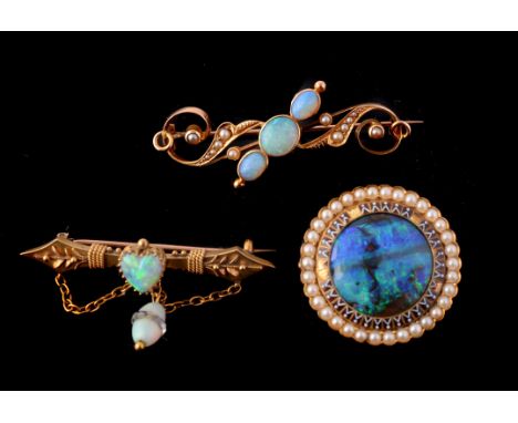 A late Victorian gold and opal brooch, circa 1900, centrally set with a heart shaped opal on a spear head bar, with an opal a