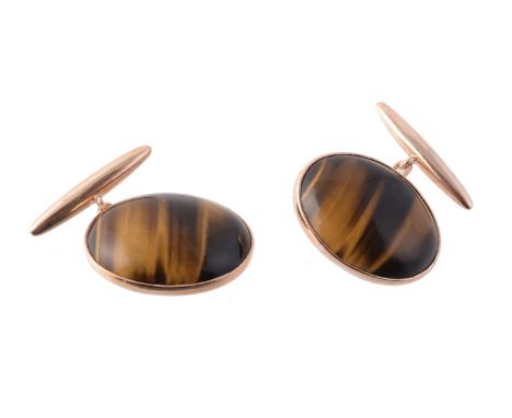 A pair of 1970s tiger's eye cufflinks, the oval cabochon tiger's eyes in rub over mounts, with chain link connection and T ba