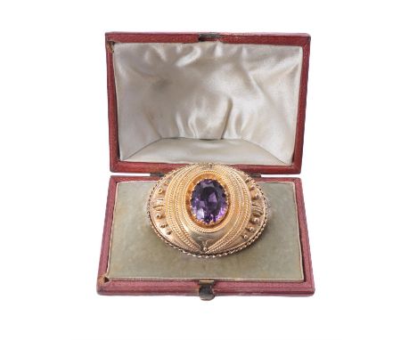 A late Victorian amethyst brooch, circa 1880, the oval mixed cut amethyst claw set in a bead and rope work oval mount, with a