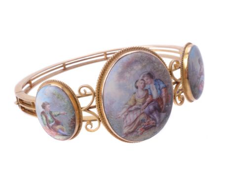 Y A late 19th century Swiss enamel hinged bangle, circa 1890, the three graduated oval plaques painted with young adults in r
