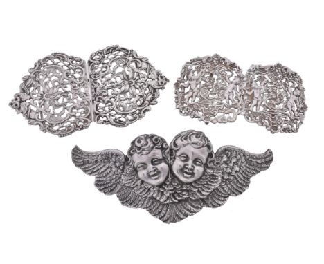 Three late Victorian silver two-part buckles, the first formed as two cherub's heads with wings by Samuel Jacob, London 1898,