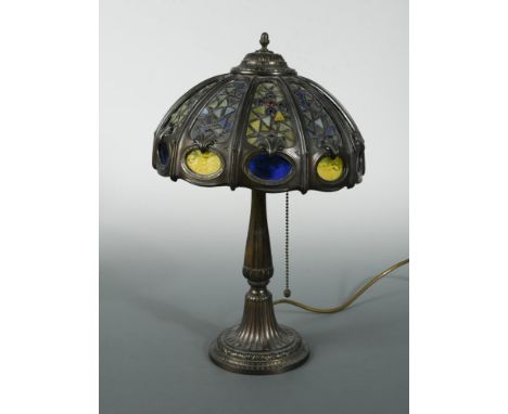 A bronzed table lamp in the manner of Tiffany, the domed shade with leaded stained glass panels 41cm (16in)  