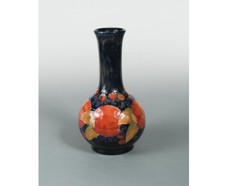 A Moorcroft Pomegranate pattern bottle vase, the fruits painted to a deep blue ground, painted and impressed marks 24cm (9in)