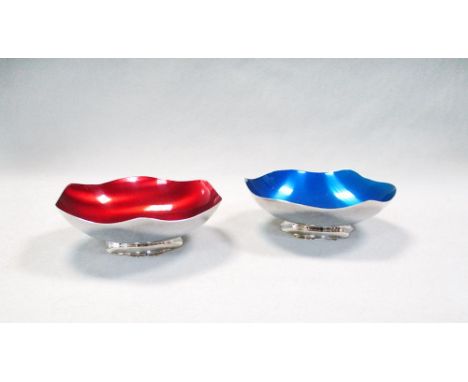 A pair of Danish enamelled electroplate dishes, probably by Carl Cohr, the shaped circular bowls raised on spreading feet, on