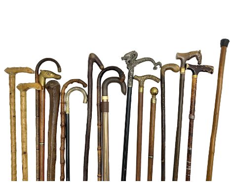 Collection of walking sticks, to include a a modern hidden umbrella stick, wooden pommel example inscribed 1910, two collapsi