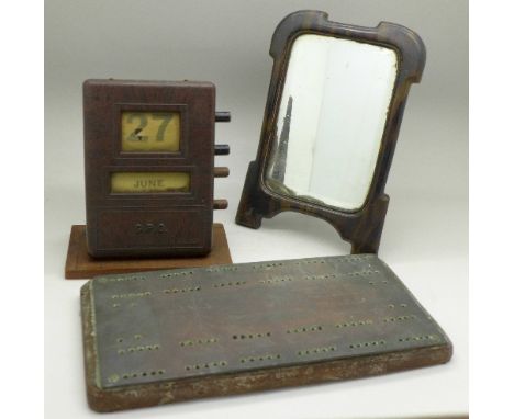 A copper printing plate cribbage board, a G.P.O. Bakelite perpetual calendar and a faux tortoiseshell mirror