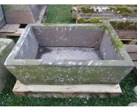 A natural stone trough of rectangular form, 88cm long x 57cm wide x 32cm high approx (two sections, detached/broken base)