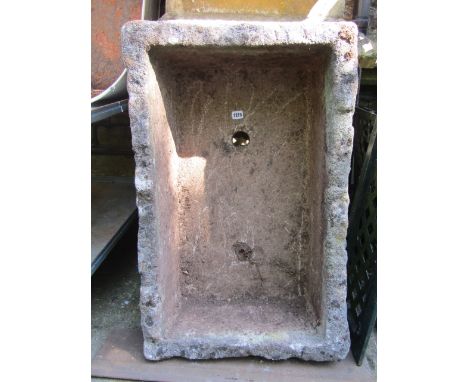 A weathered garden trough of rectangular form with two drainage holes and rough hewn appearance, 86 cm long x 56 cm wide x 26