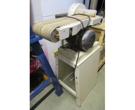 An Axminster electric belt sander model number AS609, belt size 150 x 1220 mm (6 x 48 inches) raised on a stand