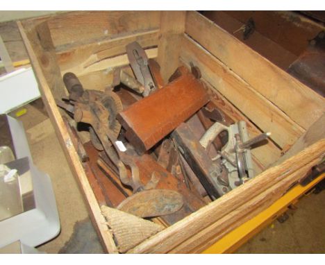 A timber crate containing a quantity of vintage wood working tools, mainly planes