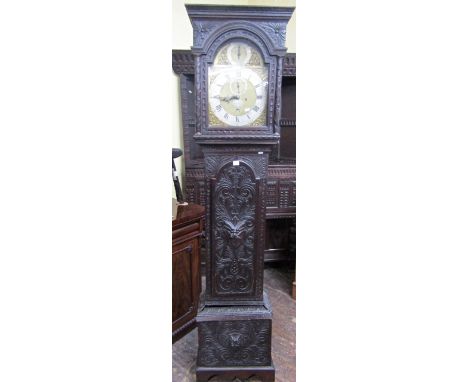 A Georgian long case clock set in a later carved case, the broken arch brass dial with silvered chapter ring and eight day st