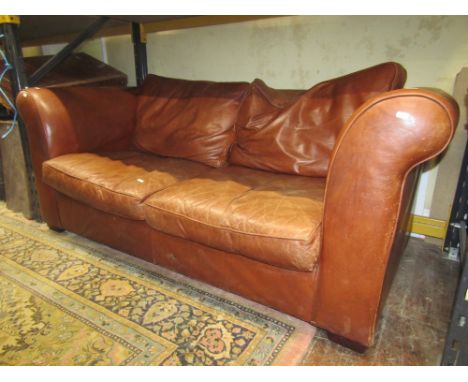 A Laura Ashley 'Burgess' leather two seat sofa with scrolled arms and loose cushions, in a mid tan colourway, 185cm long